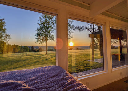 [Bedroom] [The View] slidertag; Bedroom View ; Nestled by windows, take in the sunrise from the super comfy queen-sized Purple Mattress, offering a cozy retreat with blinds for privacy.